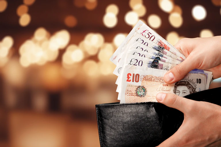 Open purse with ten, 20 and 50 pound notes.