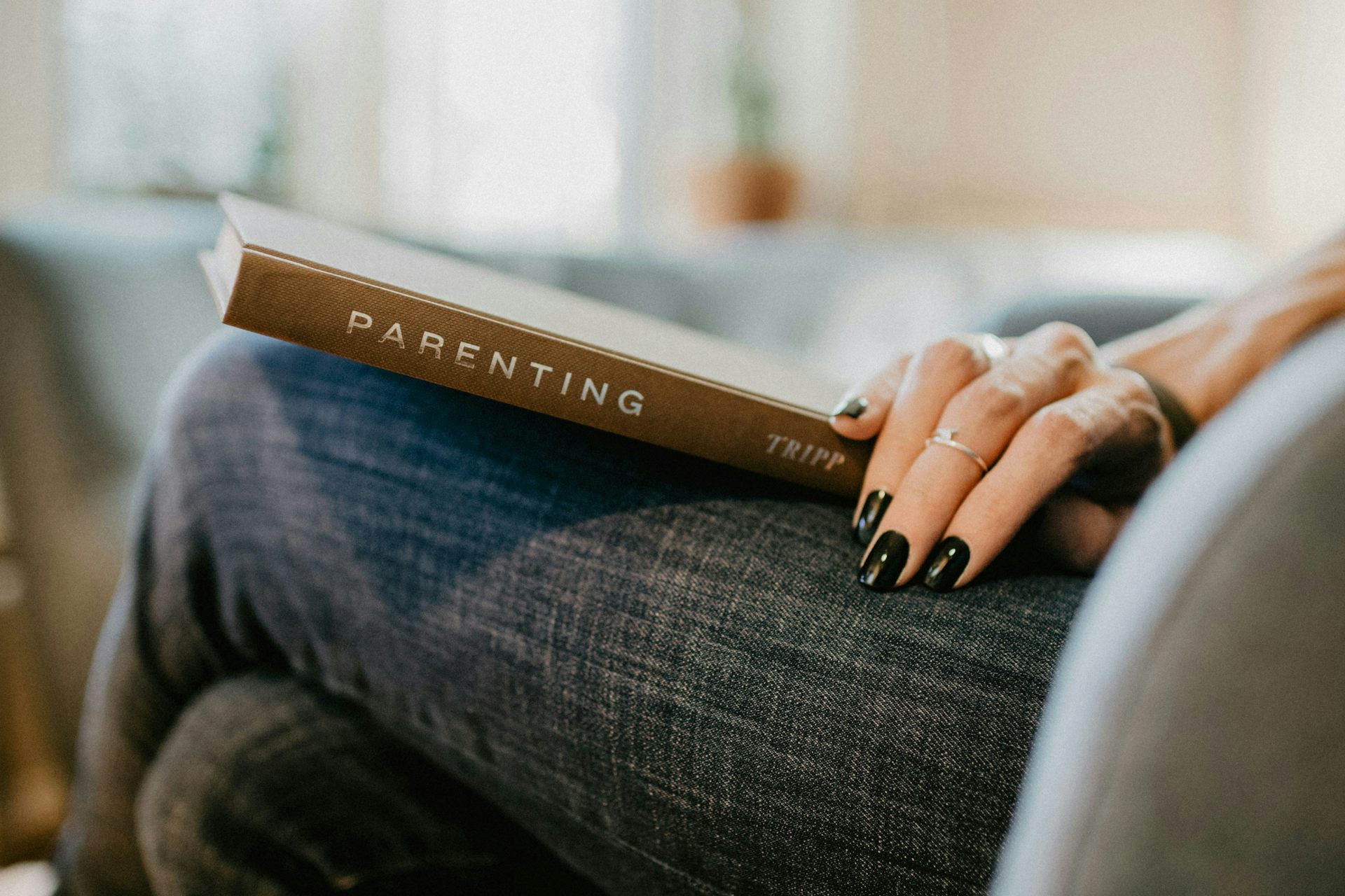 A person reading a book called parenting.
