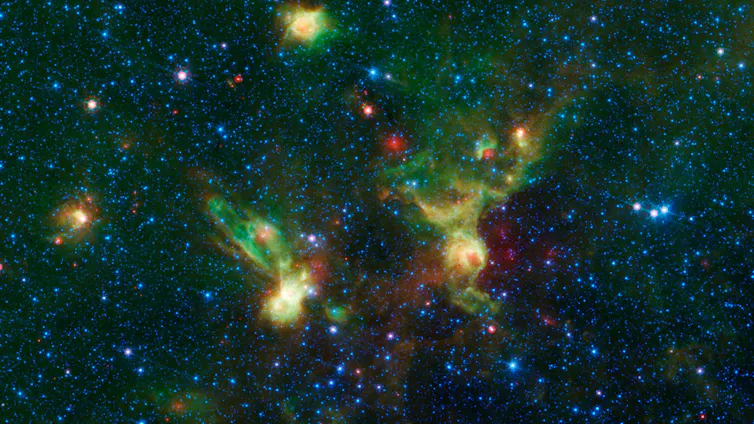 A photo of space, with some bright spots representing nebulae, including a bright spot that looks like the disc-shaped hull of the starship Enterprise from Star Trek