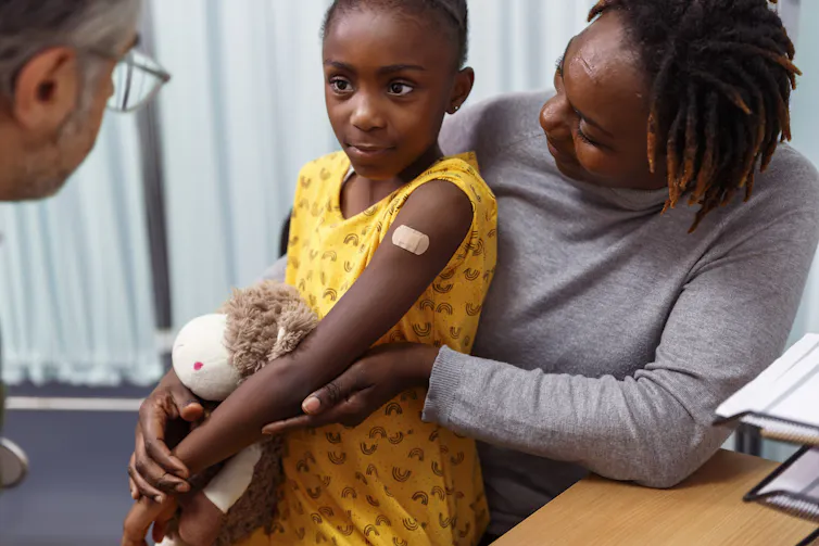 A young girl wears a bandage after getting the flu vaccine.