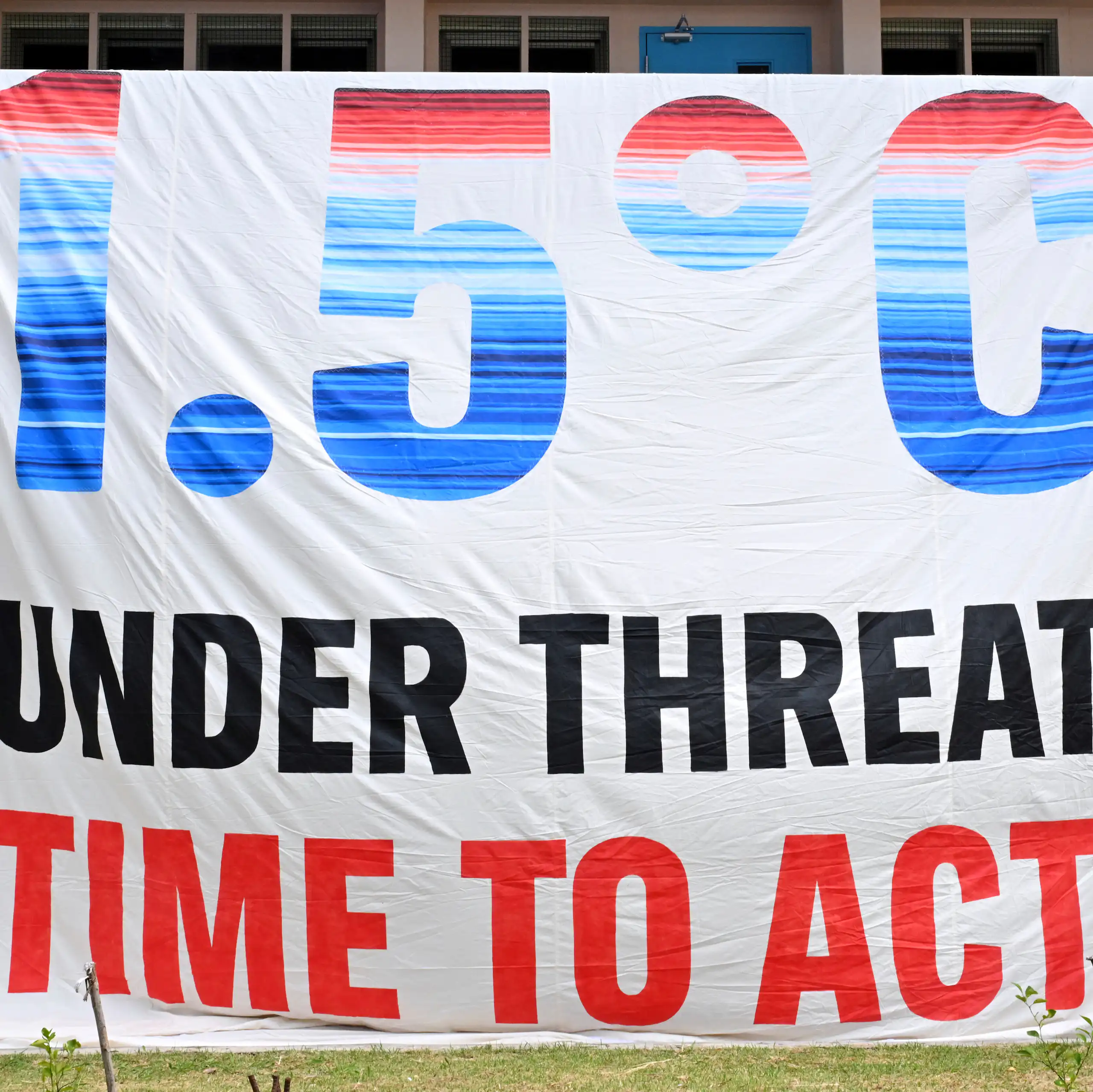 a large white banner reading: 1.5 degrees Celsius under threat: time to act!