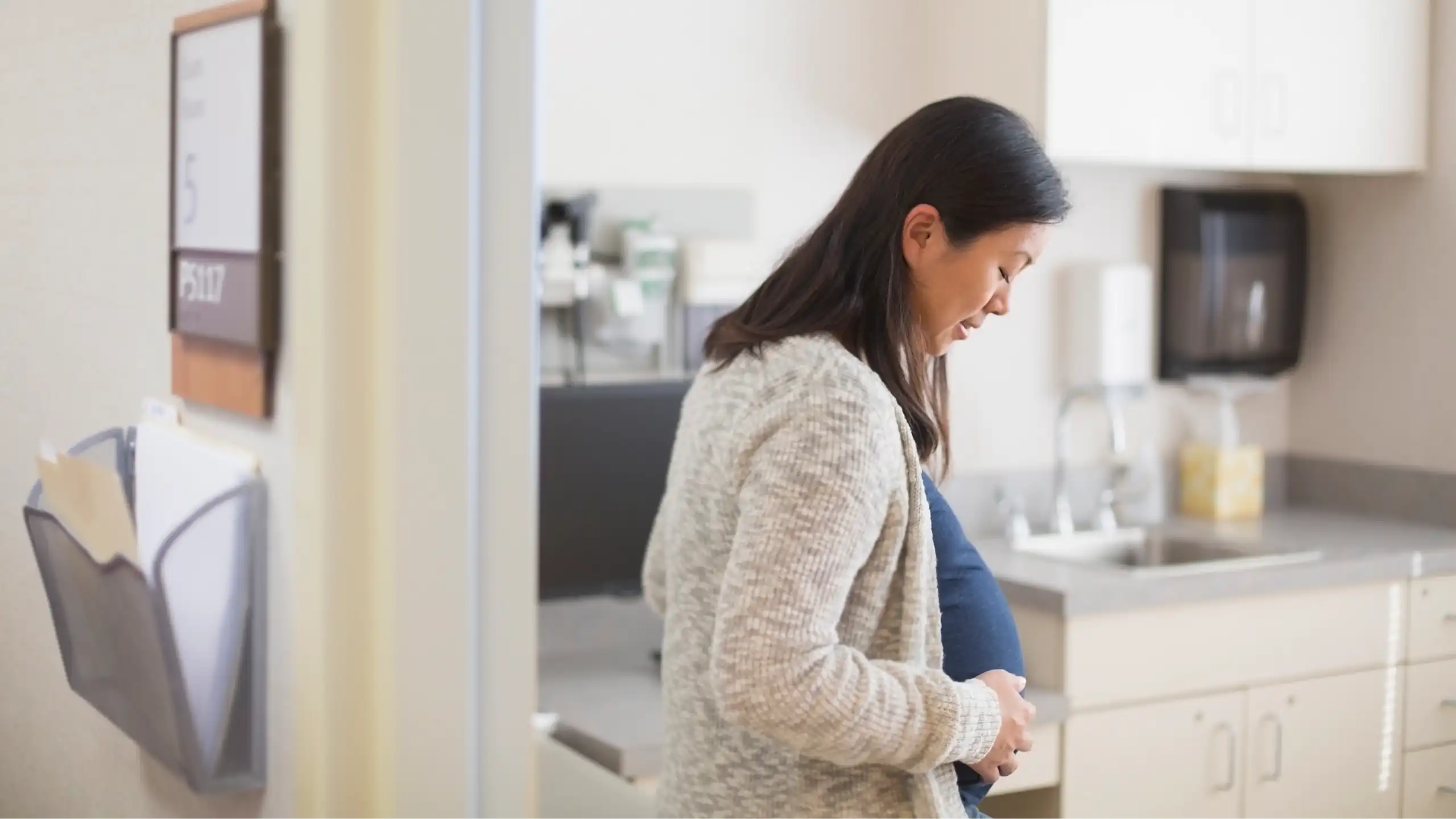 A pregnant woman enters a clinic room