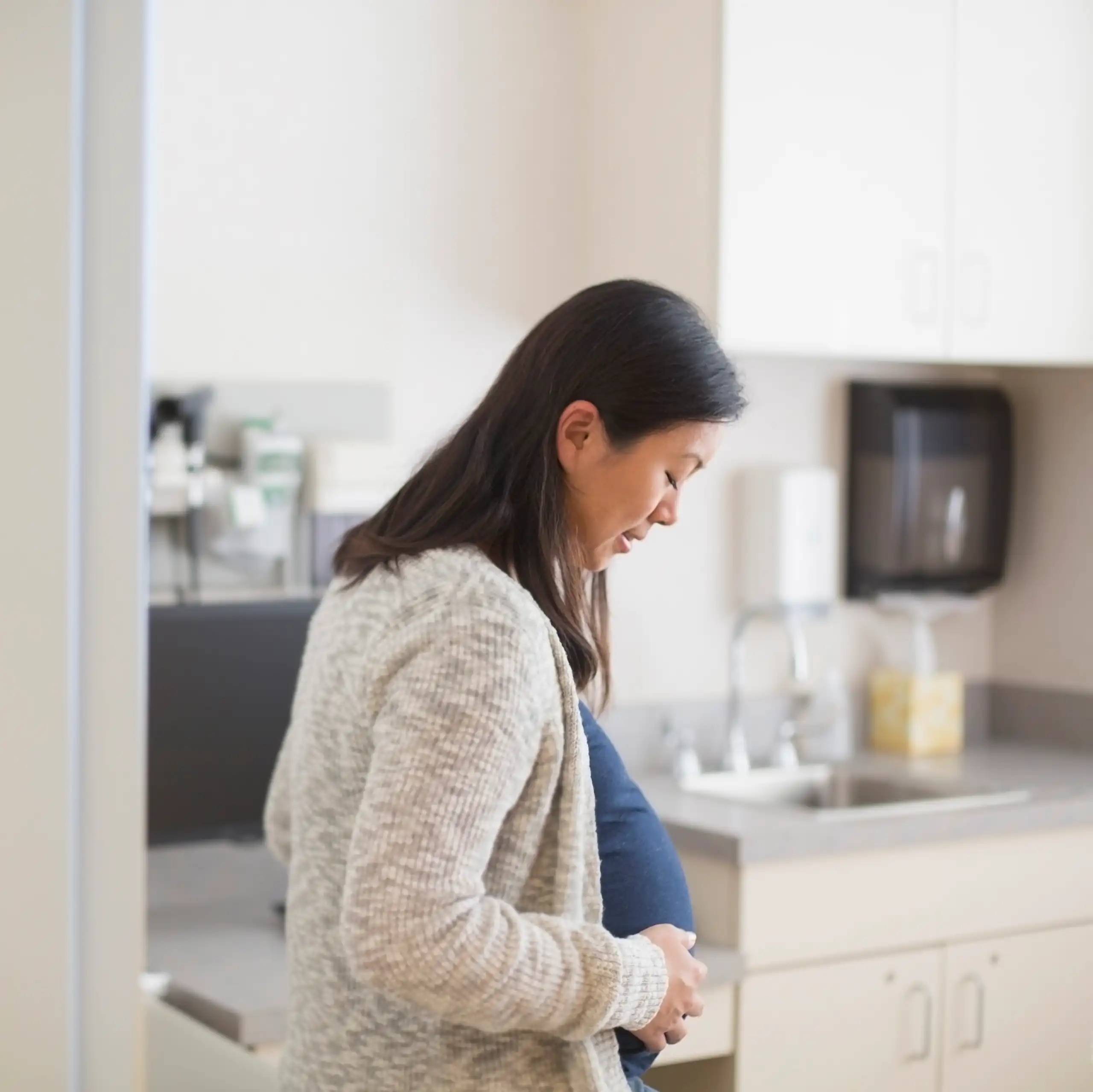 A pregnant woman enters a clinic room