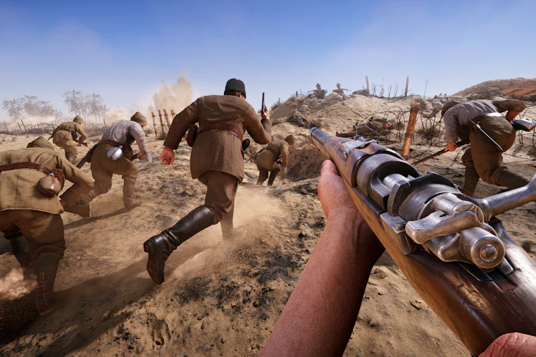 First-person view of a soldier holding a rifle while other soldiers run across a dusty battlefield towards fortified trenches and barbed wire.