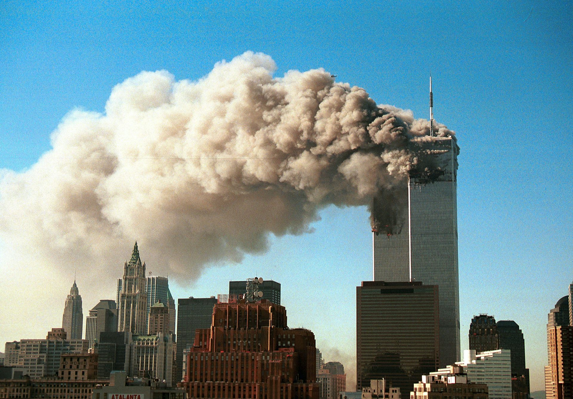 The twin towers in New York, billowing smoke after being attacked on 9/11, 2001.