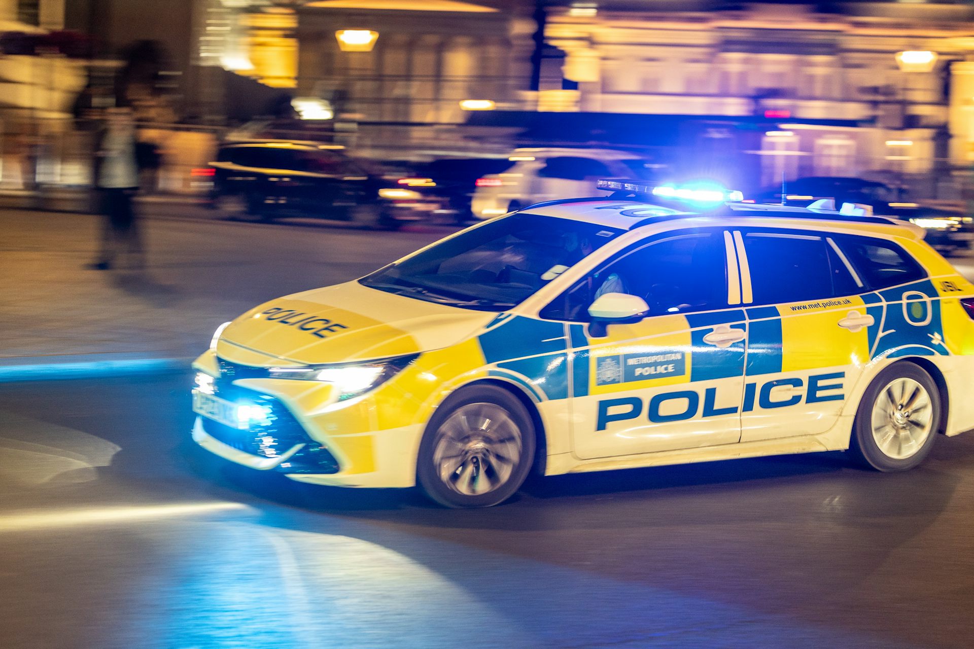 blurred shot of a speeding police car at night in london