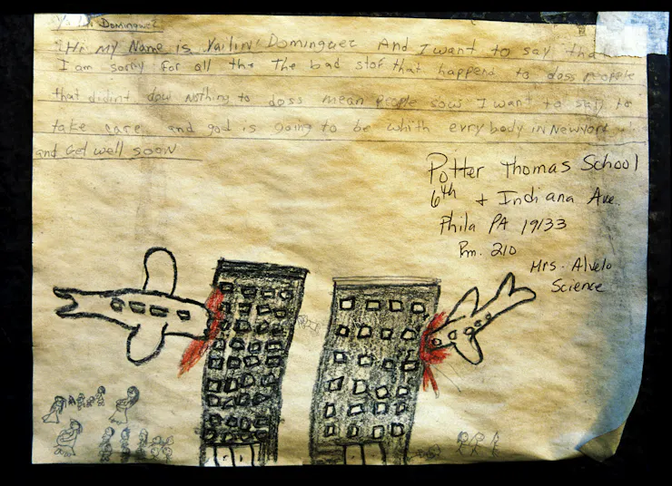 A child's note expressing sorrow for the victims of the 9/11 terrorist attacks, accompanied by a drawing of two planes smashing into two towers.