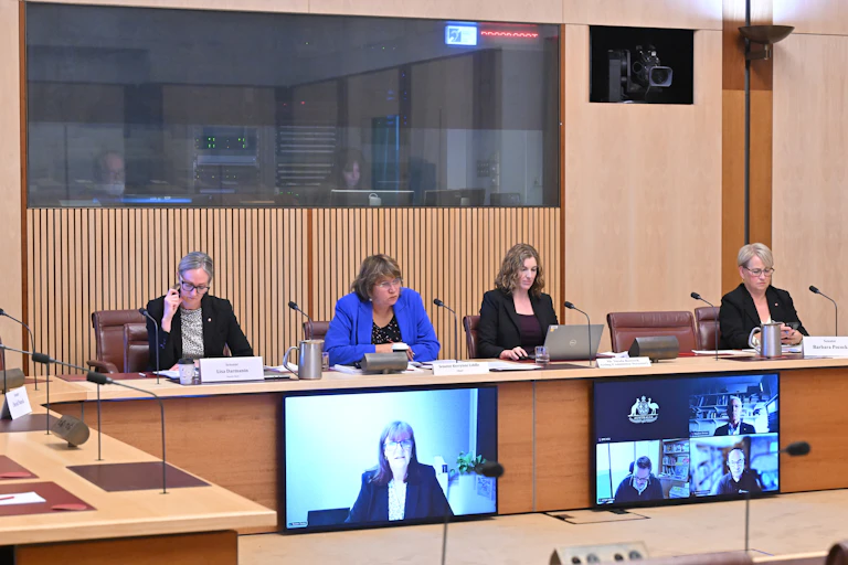 A panel of people seated at a desk