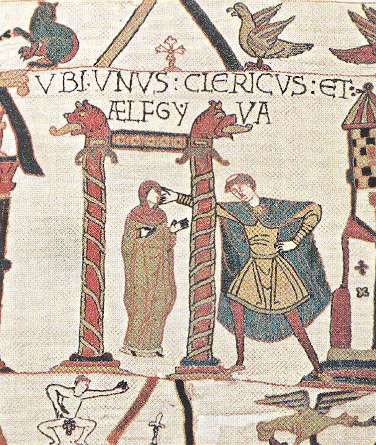 A scene from the Bayeux tapestry showing a woman with a priest touching her head and a naked man in the margin beneath.
