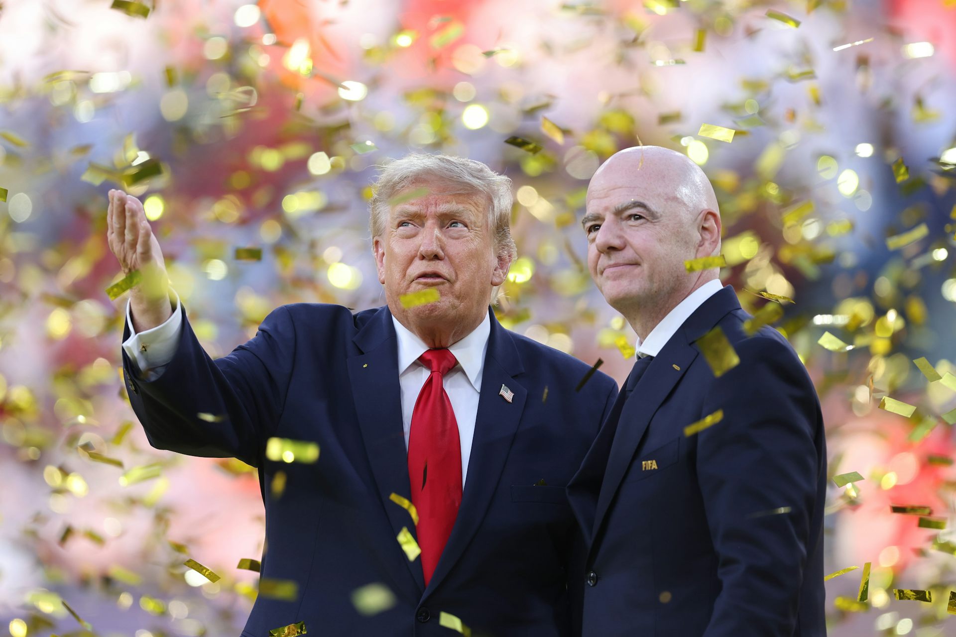 Two men. in suits are surrounded by gold tickets.