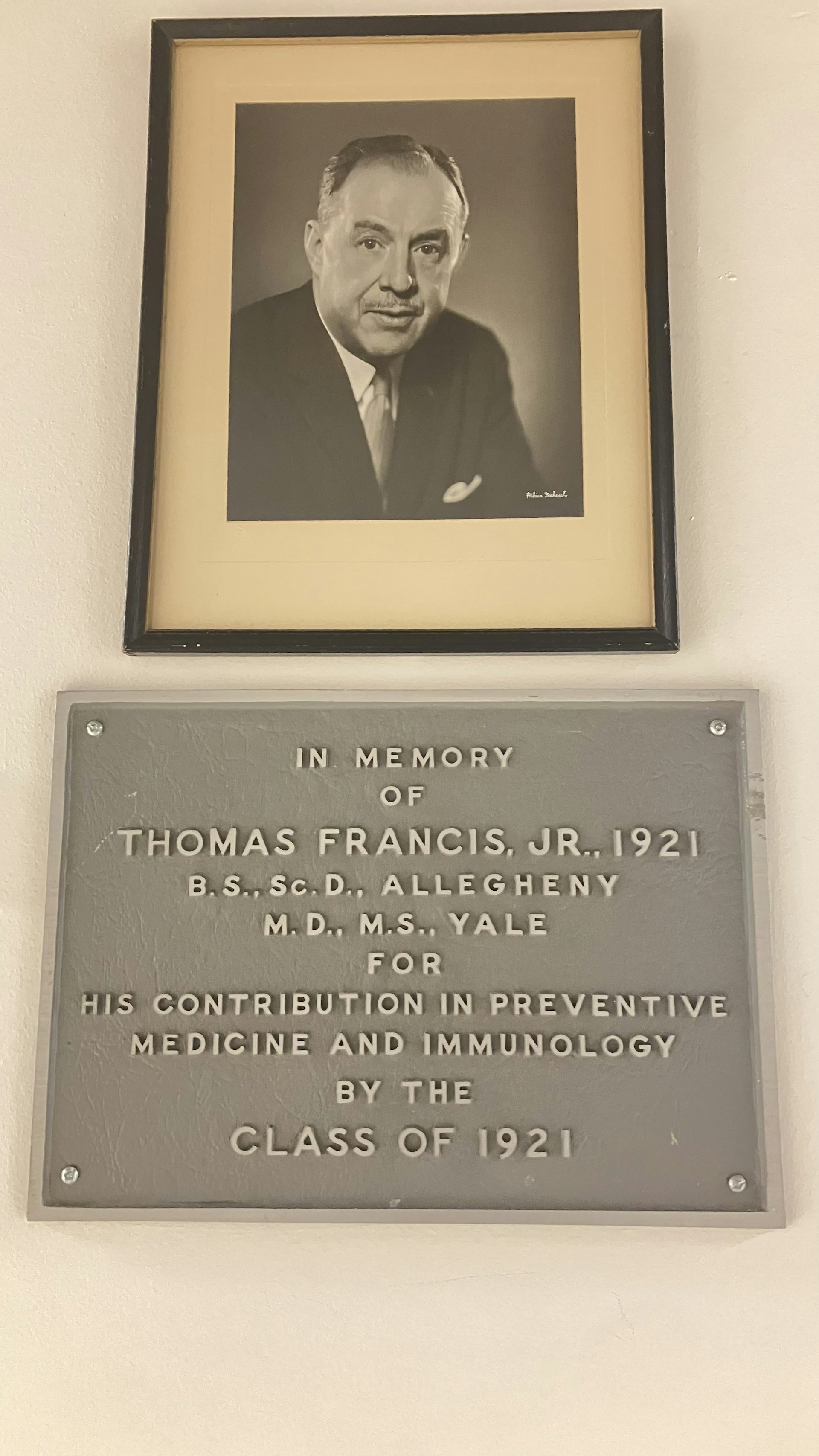 A photo and plaque hanging on a wall.