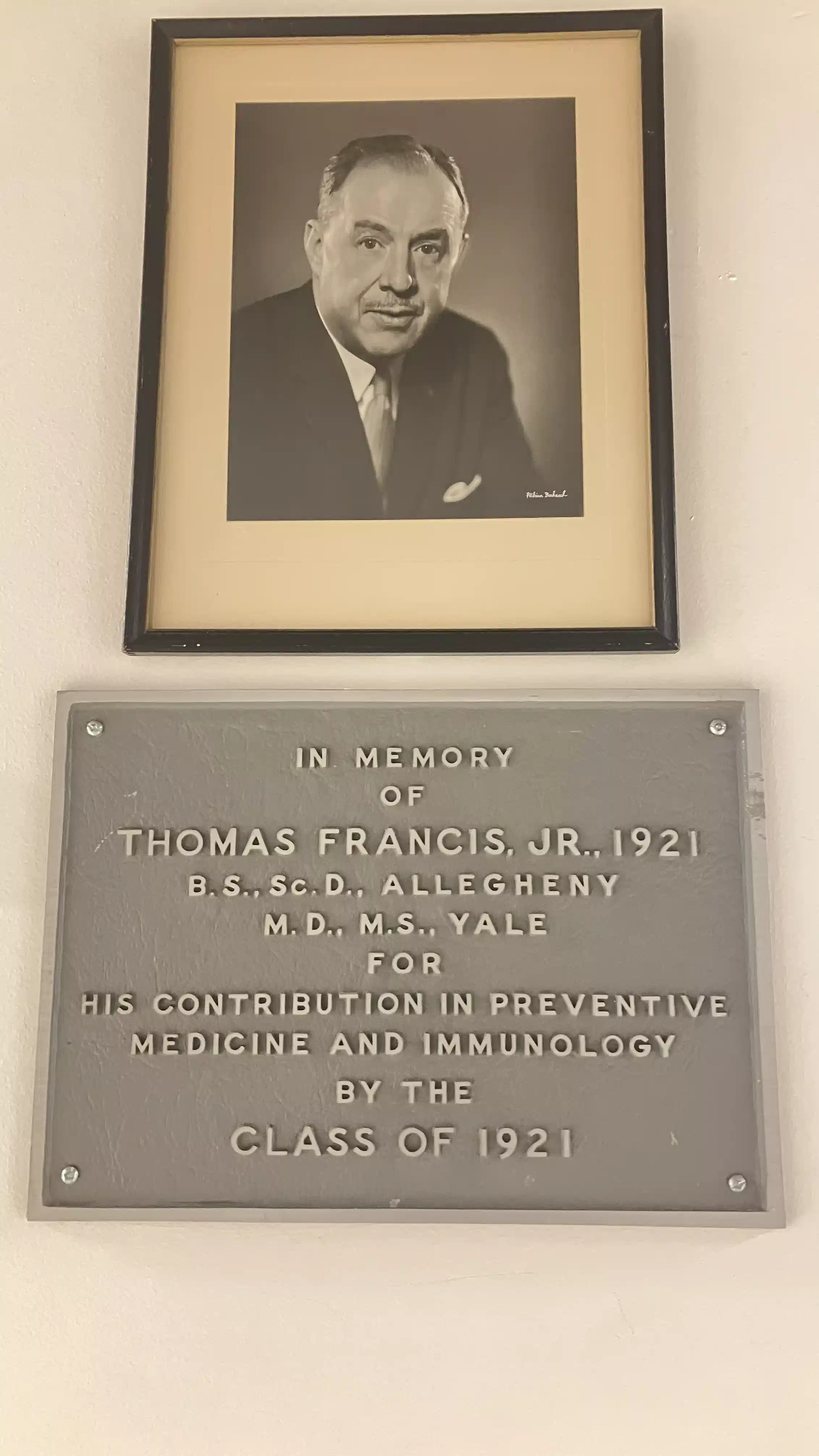A photo and plaque hanging on a wall.