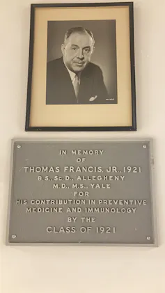 A photo and plaque hanging on a wall.