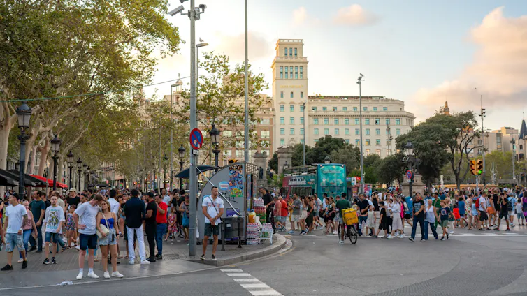Multitud de transeúntes en una esquina de la plaza Cataluña de la ciudad de Barcelona
