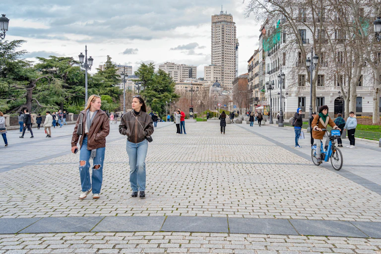 Personas caminando por una calle peatonal cerca del Palacio Real de Madrid