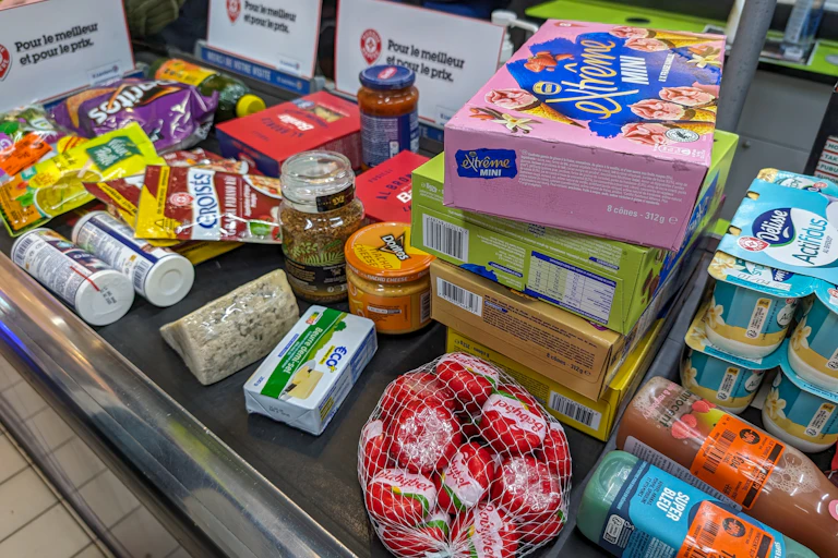 Des produits alimentaires sur un tapis de caisse au supermarché.