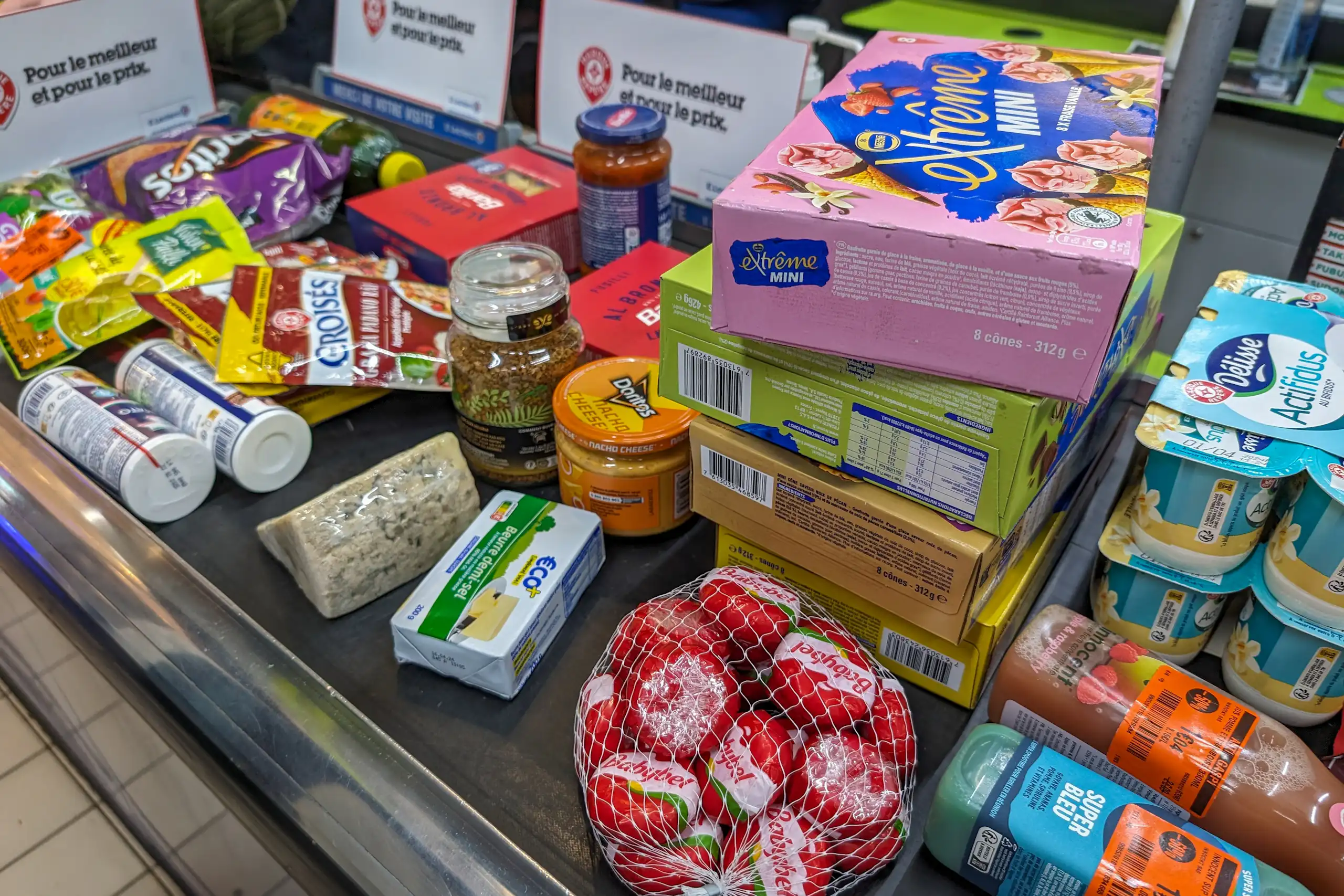 Des produits alimentaires sur un tapis de caisse au supermarché.