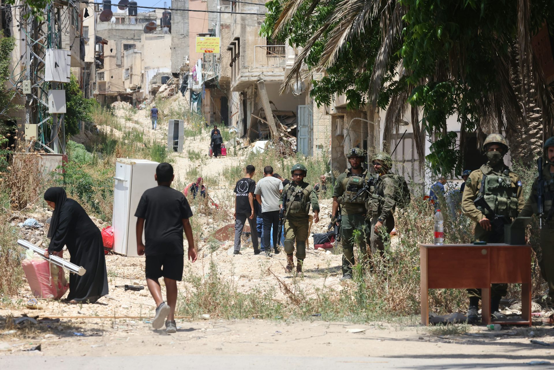 Israeli troops stand guard in a refugee camp for Palestinians.