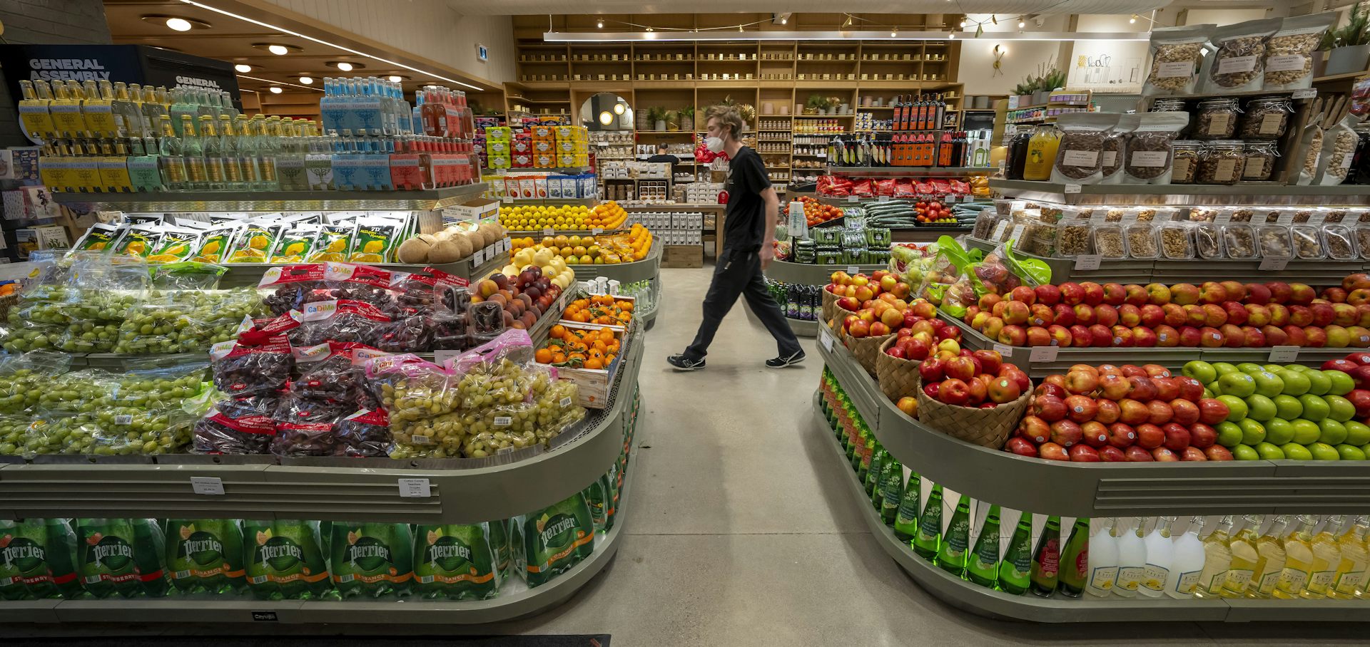 A man walking through a supermarket display of fresh produce