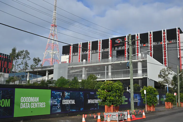 A large building behind construction fences in front of an Artarmon landmark, the radio tower.