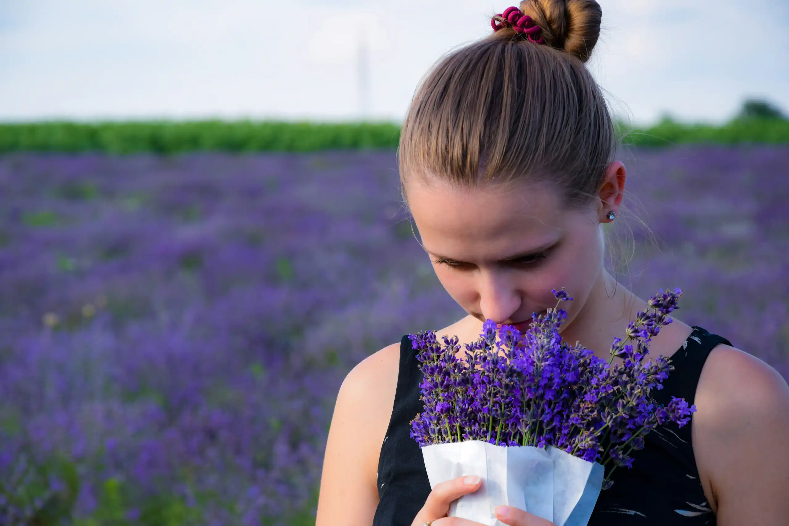 Une femme sent un bouquet de lavande.