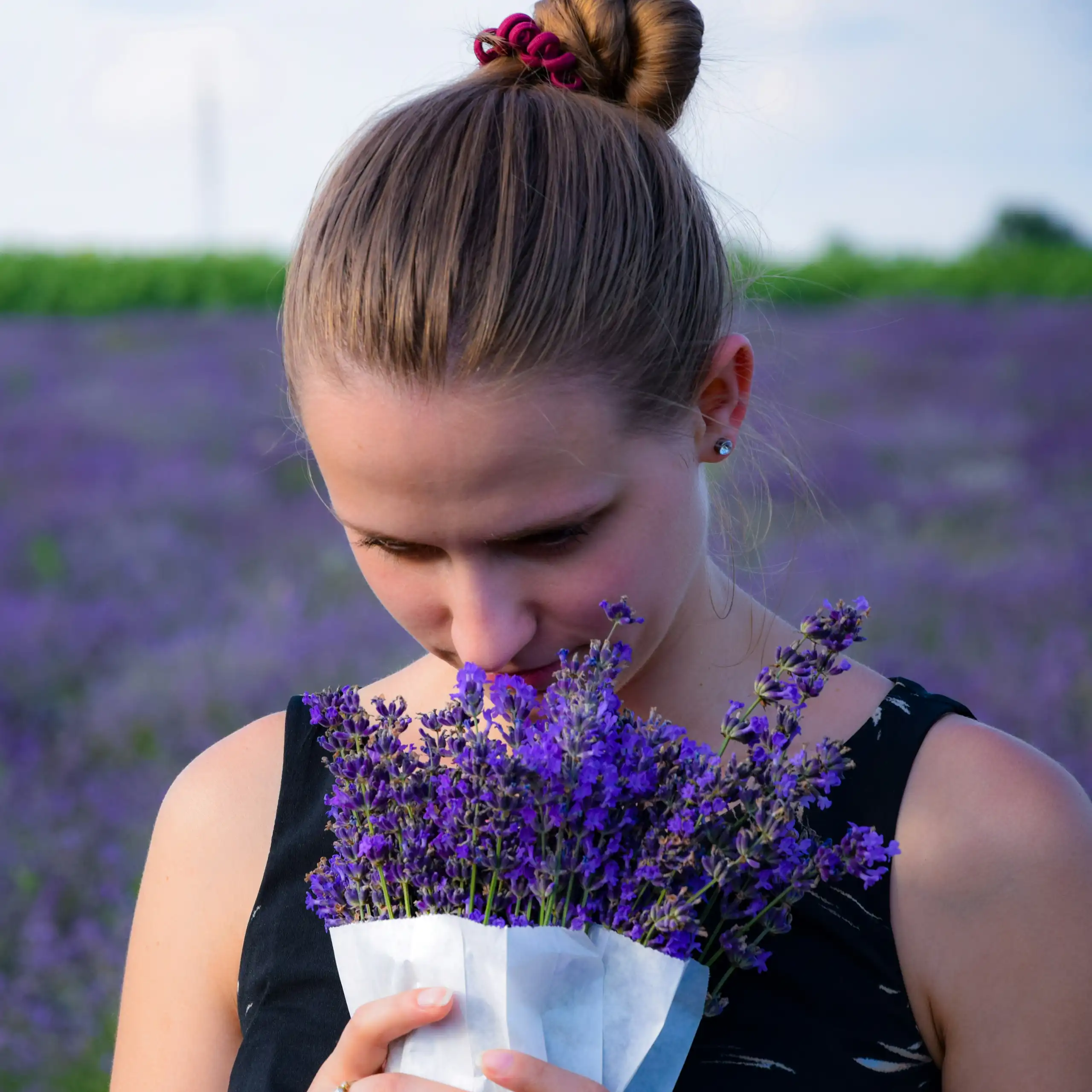 Une femme sent un bouquet de lavande.