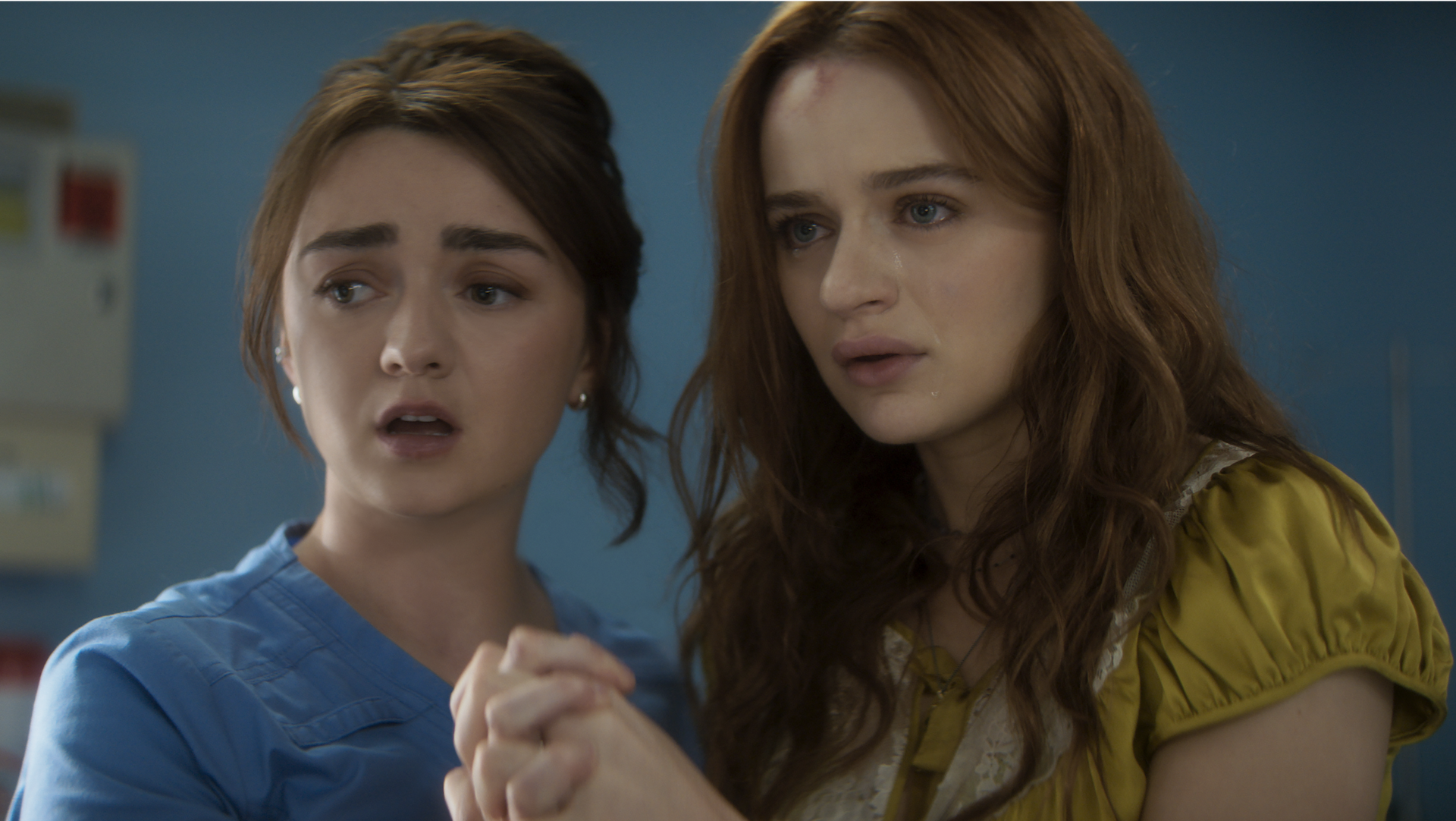 Two young girls clutching each other in fear.