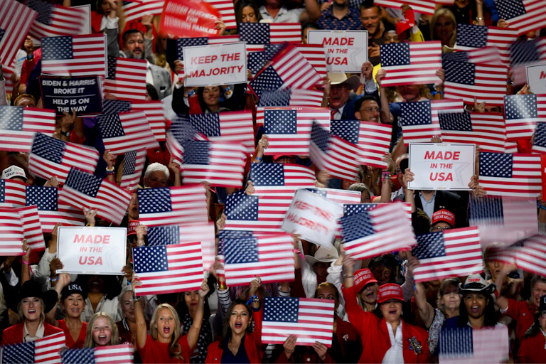 Vue des tribunes où les militants brandissent des panneaux « Keep the majority » et des drapeaux américains.