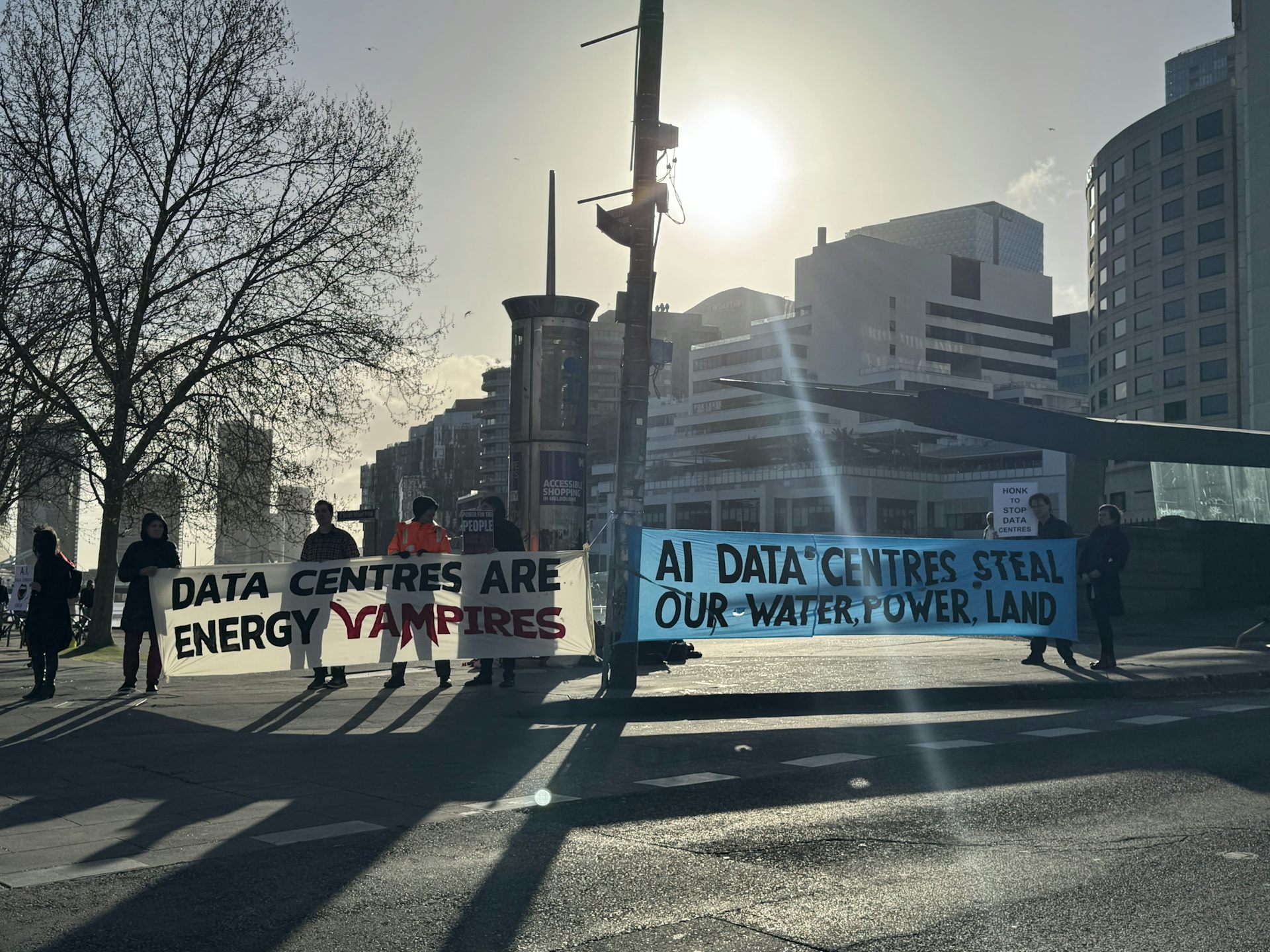 Demonstrators holding signs protesting data centres in Melbourne
