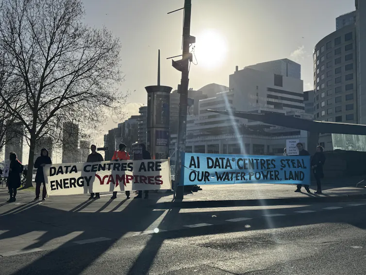 Demonstrators holding signs protesting data centres in Melbourne