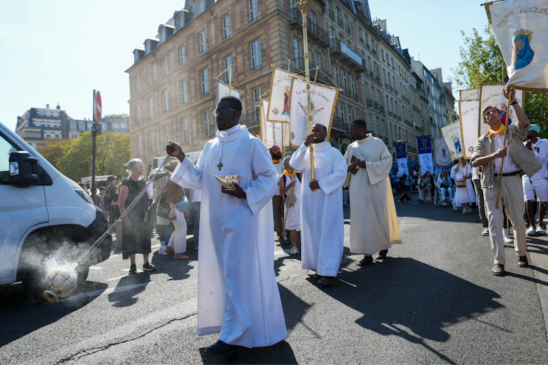 Des curés marchent devant la statue en argent de la Vierge Marie (non visible), sauvée de l'incendie dévastateur de Notre-Dame de Paris, lors de la première procession de l'Assomption depuis sa réouverture (Paris, 2025).
