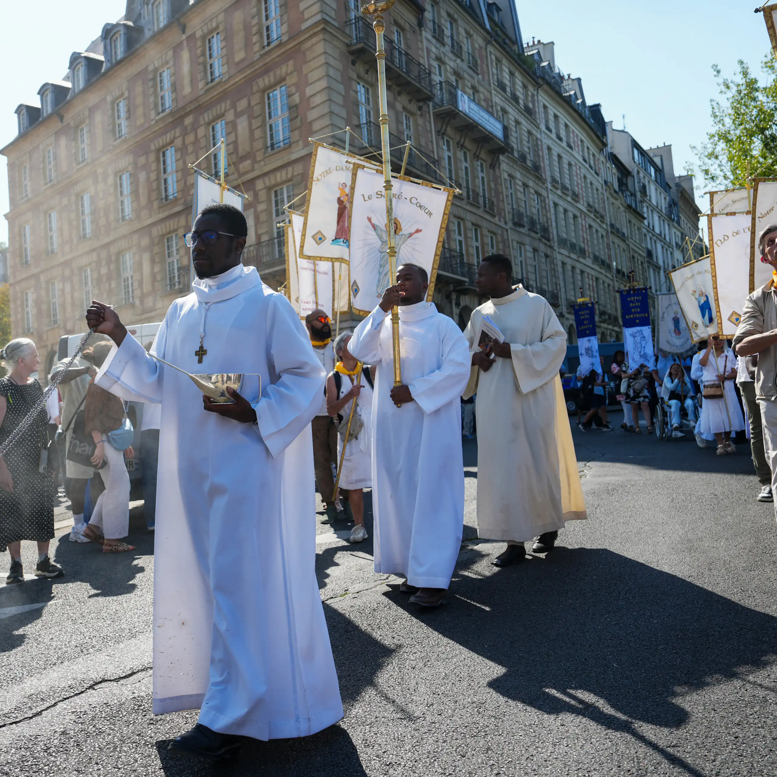 Des curés marchent devant la statue en argent de la Vierge Marie (non visible), sauvée de l'incendie dévastateur de Notre-Dame de Paris, lors de la première procession de l'Assomption depuis sa réouverture (Paris, 2025).