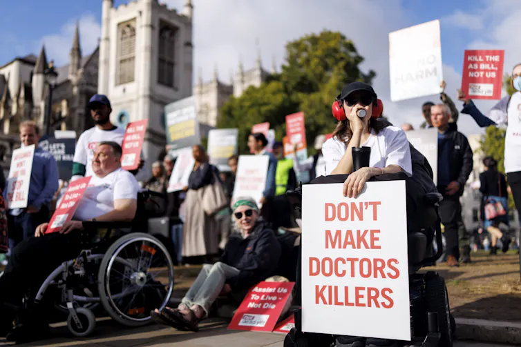 a large group of anti-assisted dying campaigners protest in front of parliament