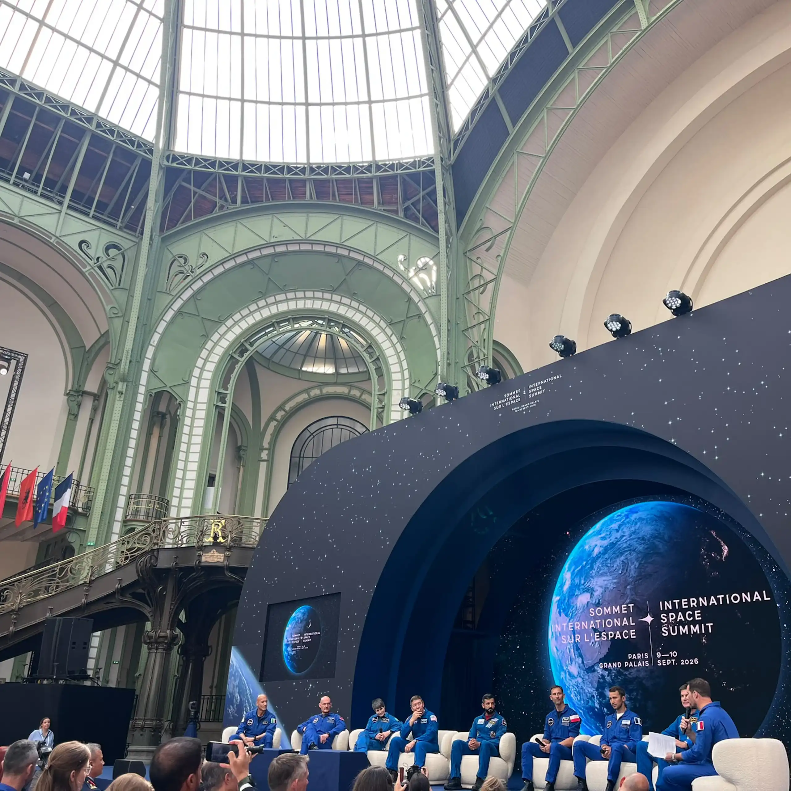 Several astronauts are debating on stage before the summit participants.