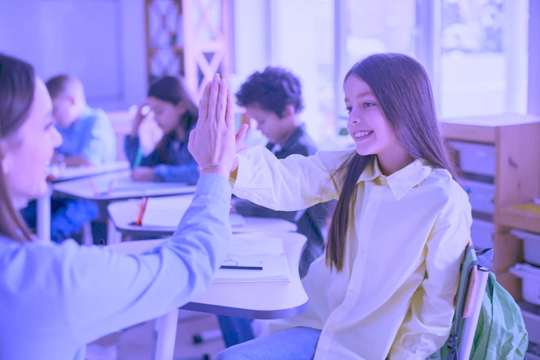 Una profesora "choca los cinco" con una alumna