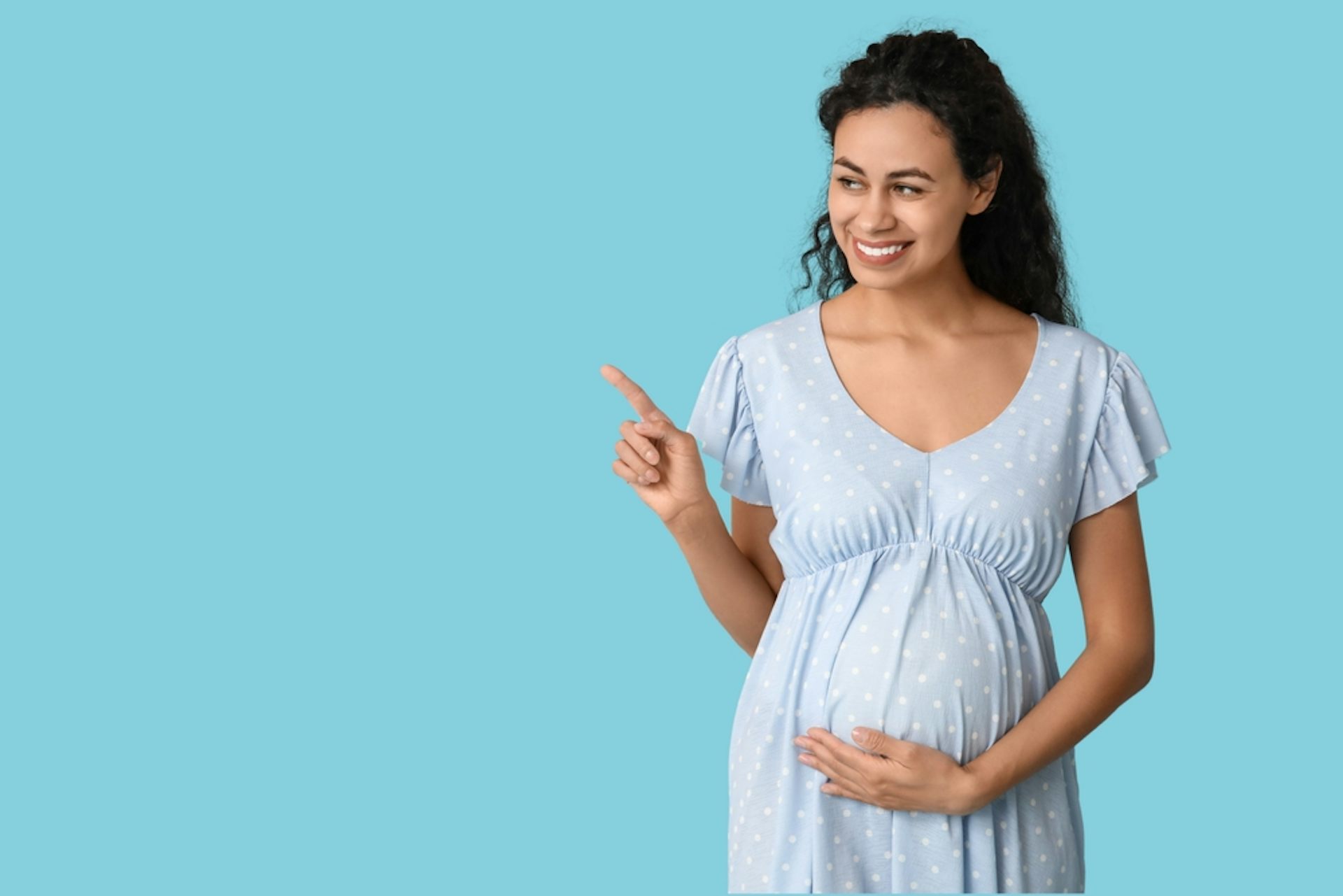 A pregnant woman against a blue background.