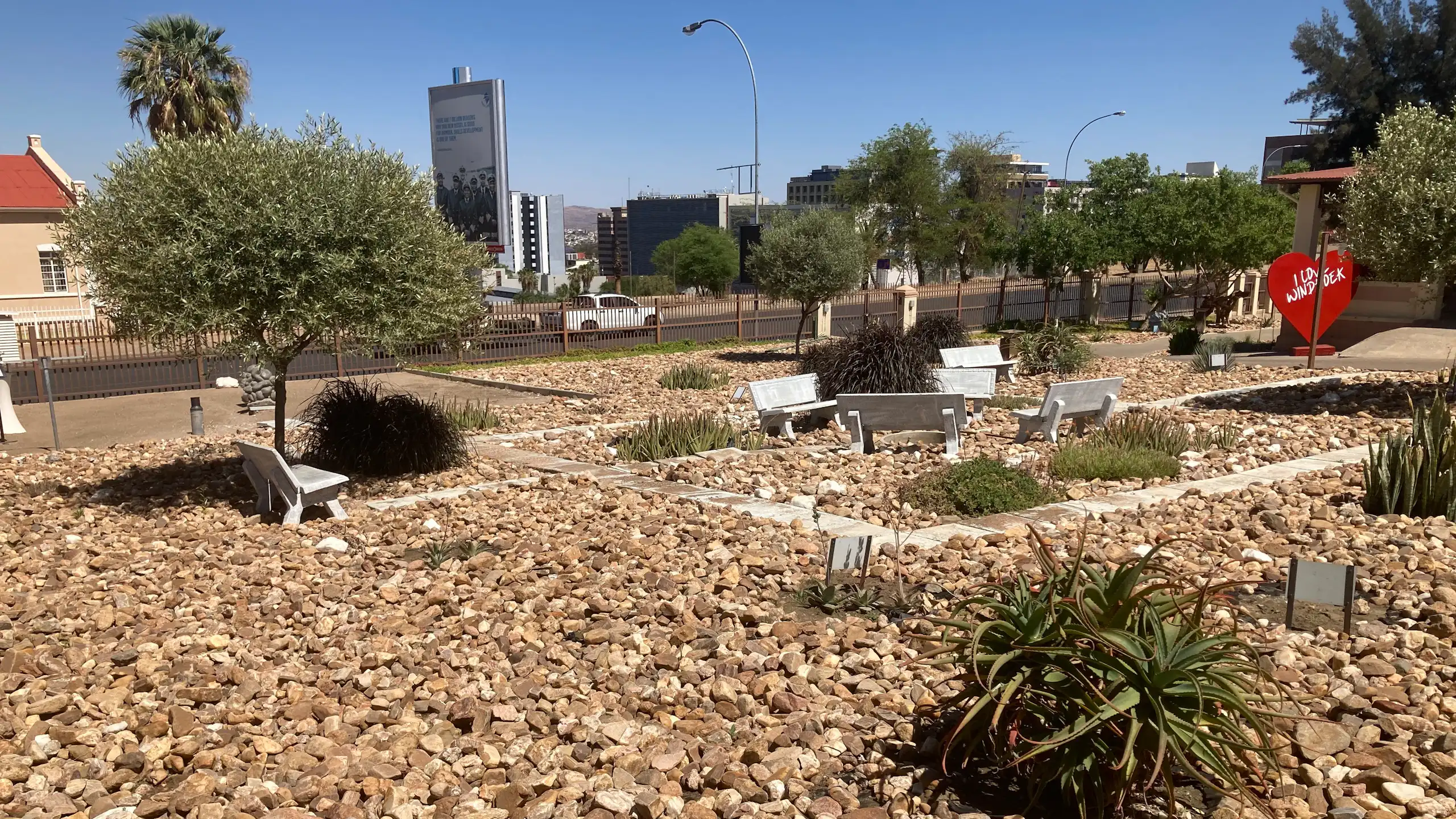 Stones and a few plants in a city landscape with some park benches