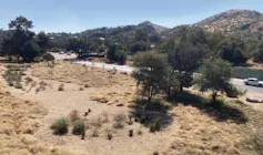 A very dry brown landscape with trees in the background