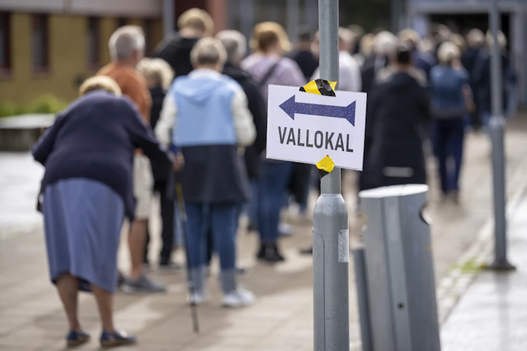Voters queue to cast their votes in Sweden's general election outside a polling station.