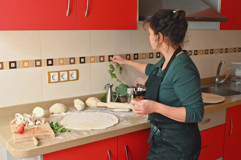 Une femme prépare un repas dans une cuisine.