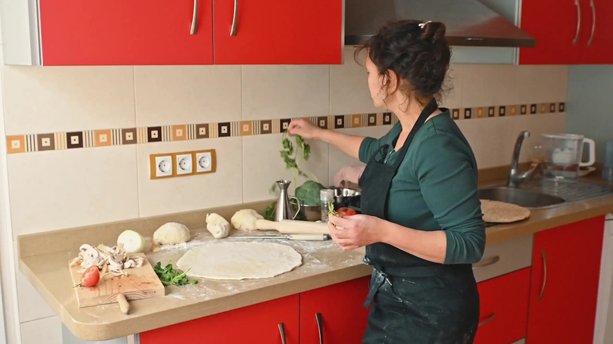 Une femme prépare un repas dans une cuisine.