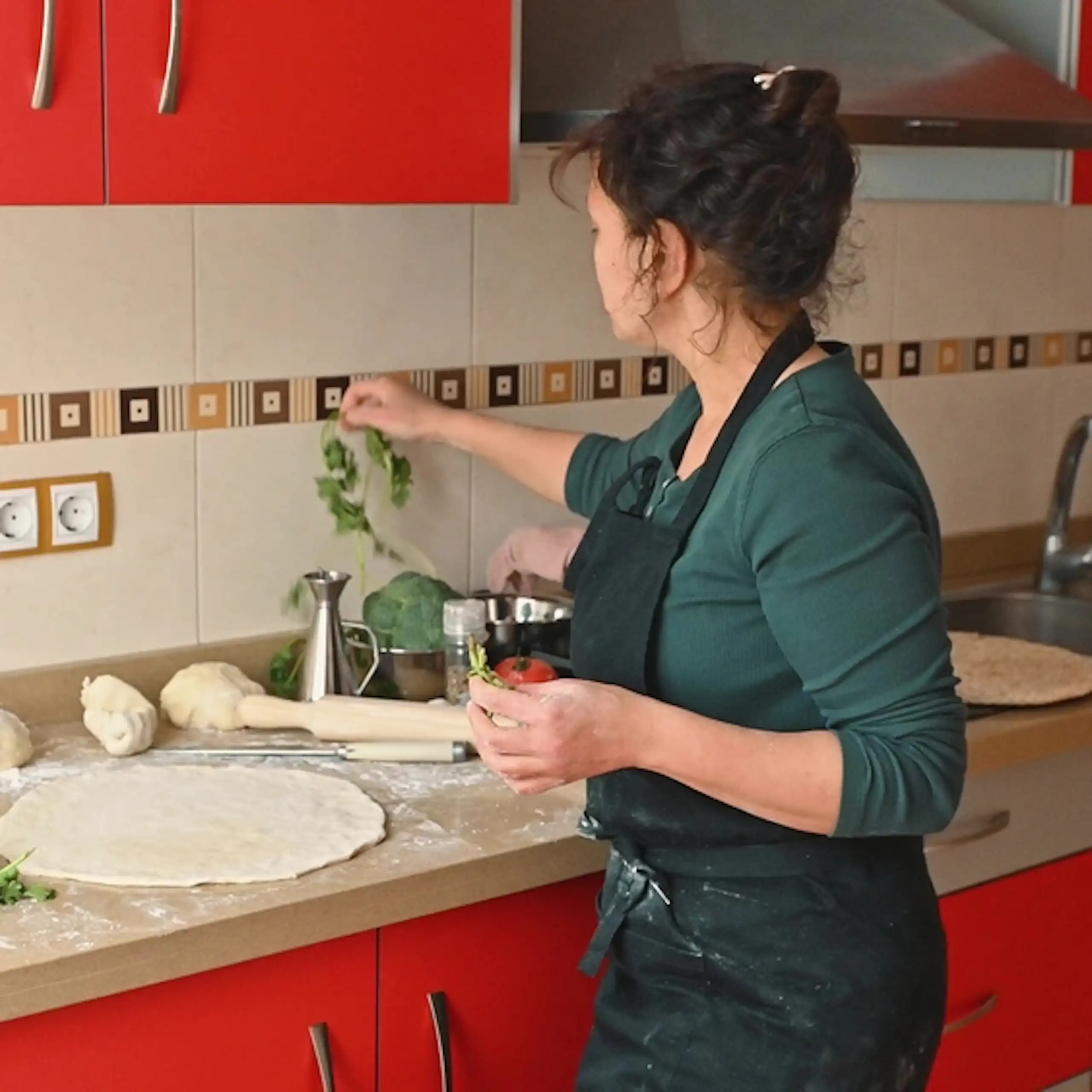 Une femme prépare un repas dans une cuisine.