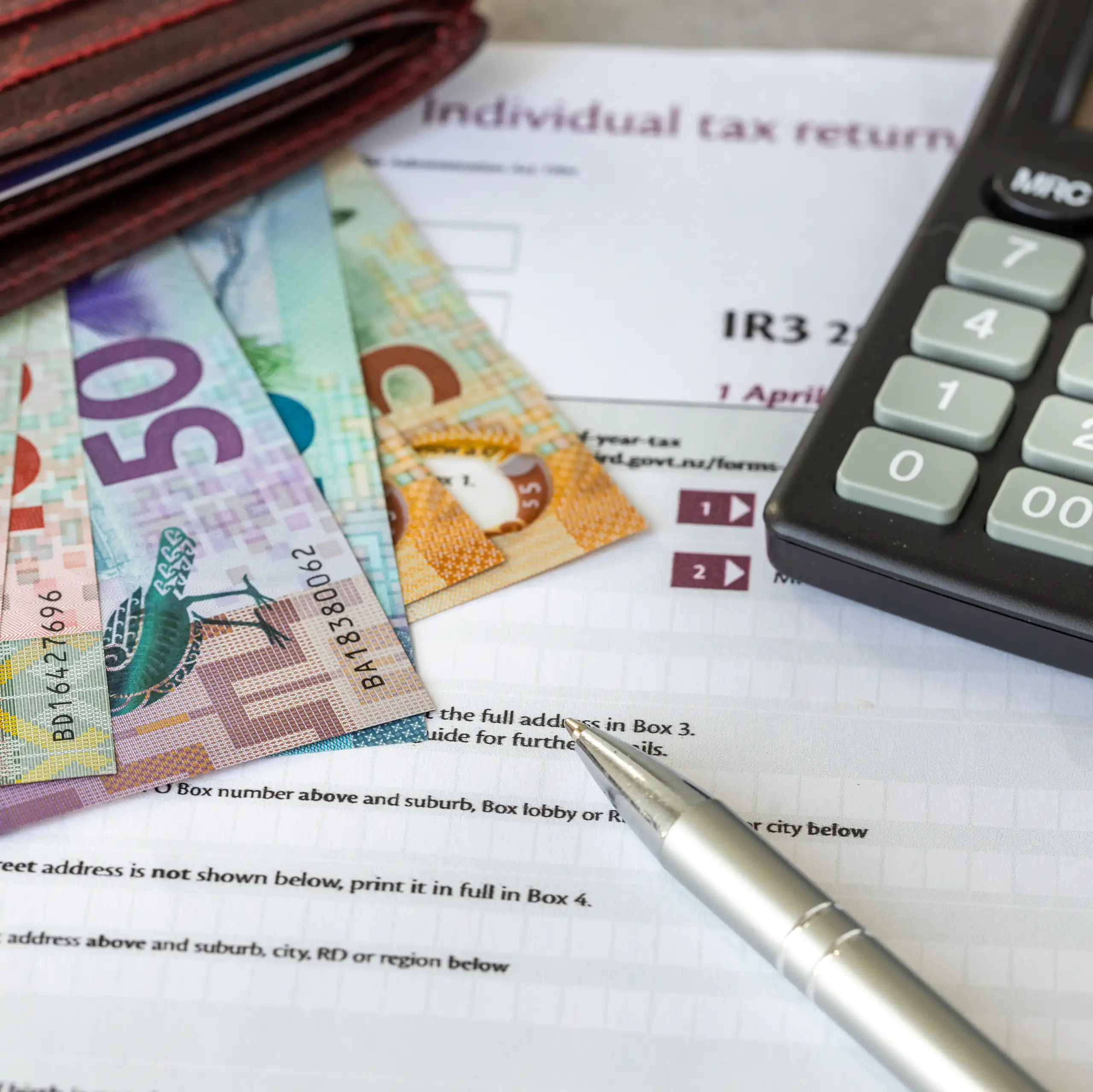 Collection of NZ currency, income tax form and calculator