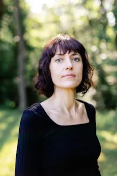 A young woman with a bob, in a forest: author Astra Taylor.