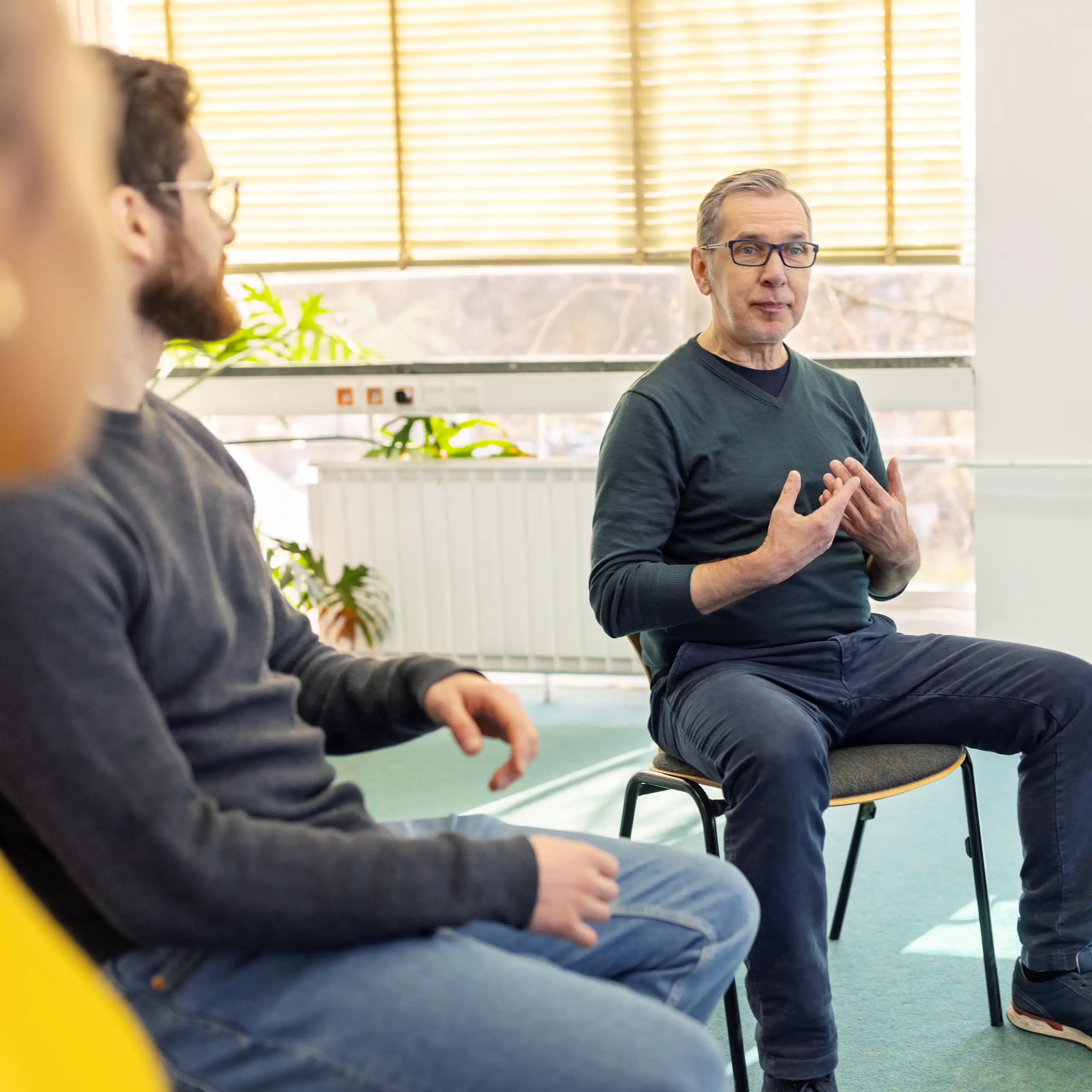 An older man talks about himself in a peer-support session