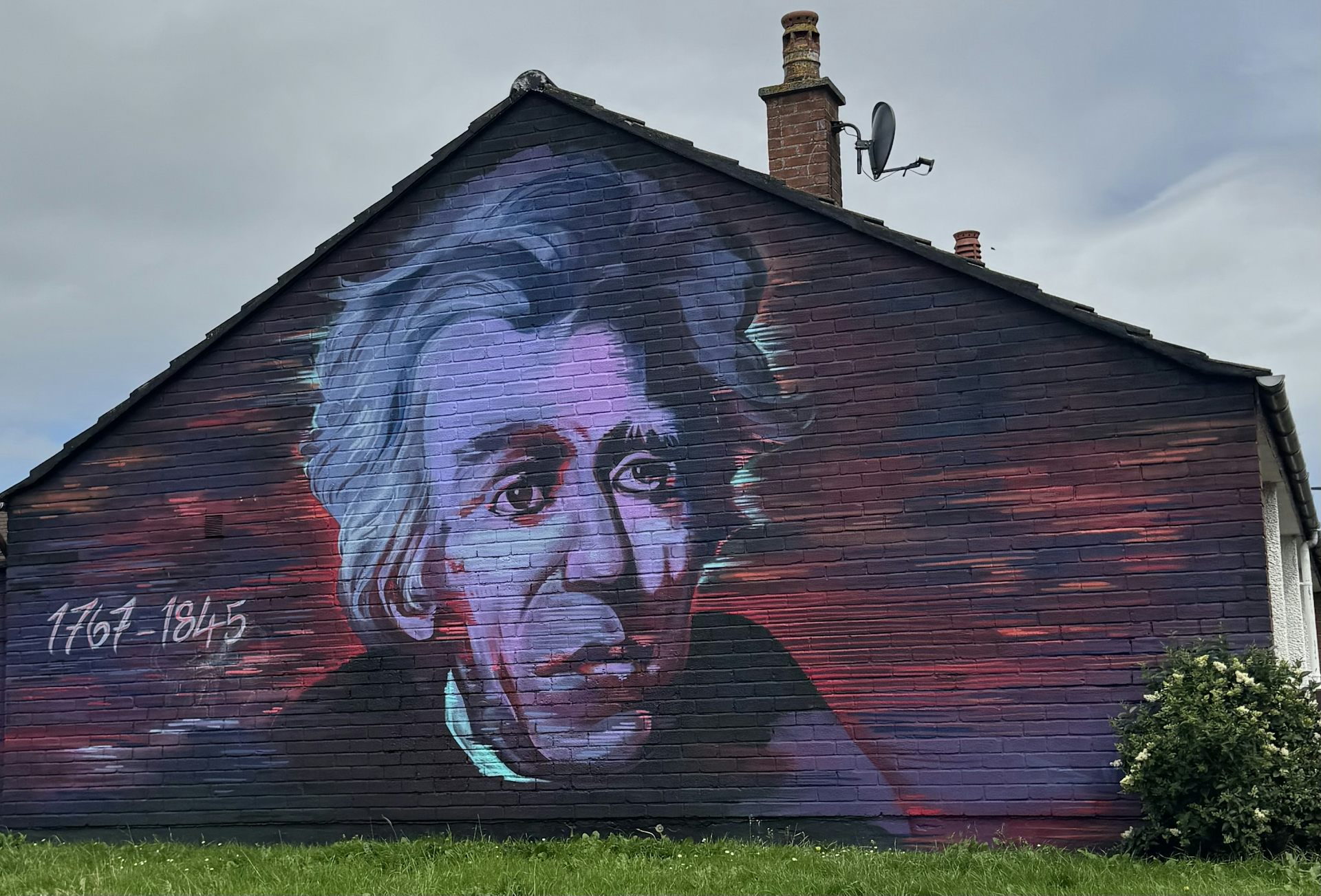 A large painting of a man's face on the side of a building