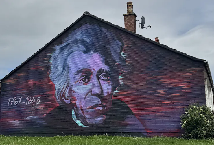 A large painting of a man's face on the side of a building