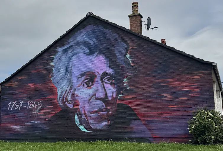 A large painting of a man's face on the side of a building