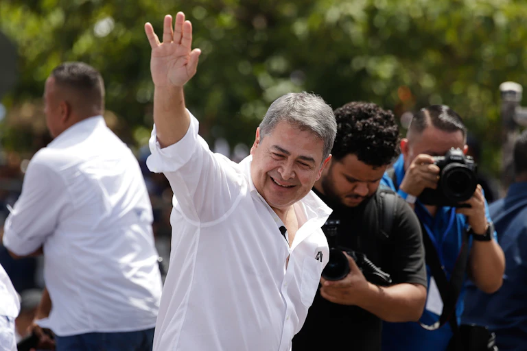 A man waves to a crow of supporters.