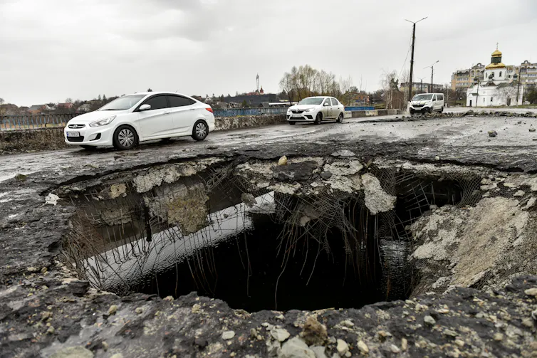 A shell crater on a damaged bridge in Makariv.